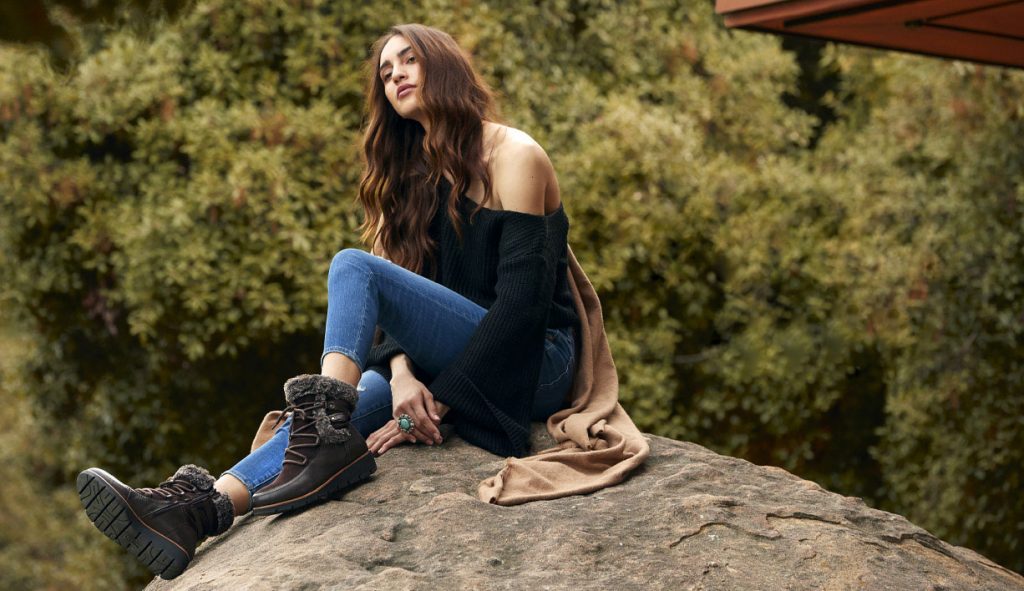Girl sitting on rock wearing Earth shoes.